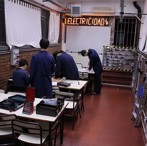Grupo de jóvenes estudiantes trabajando en el aula taller en el ensamblado de distintas piezas eléctricas