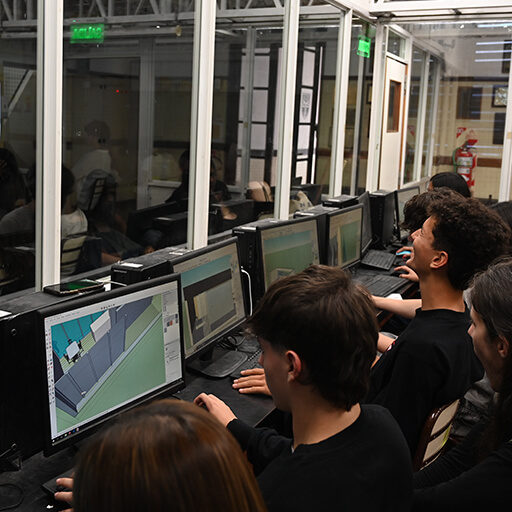 Un grupo de estudiantes en el aula de computación realizando trabajos en Autocad
